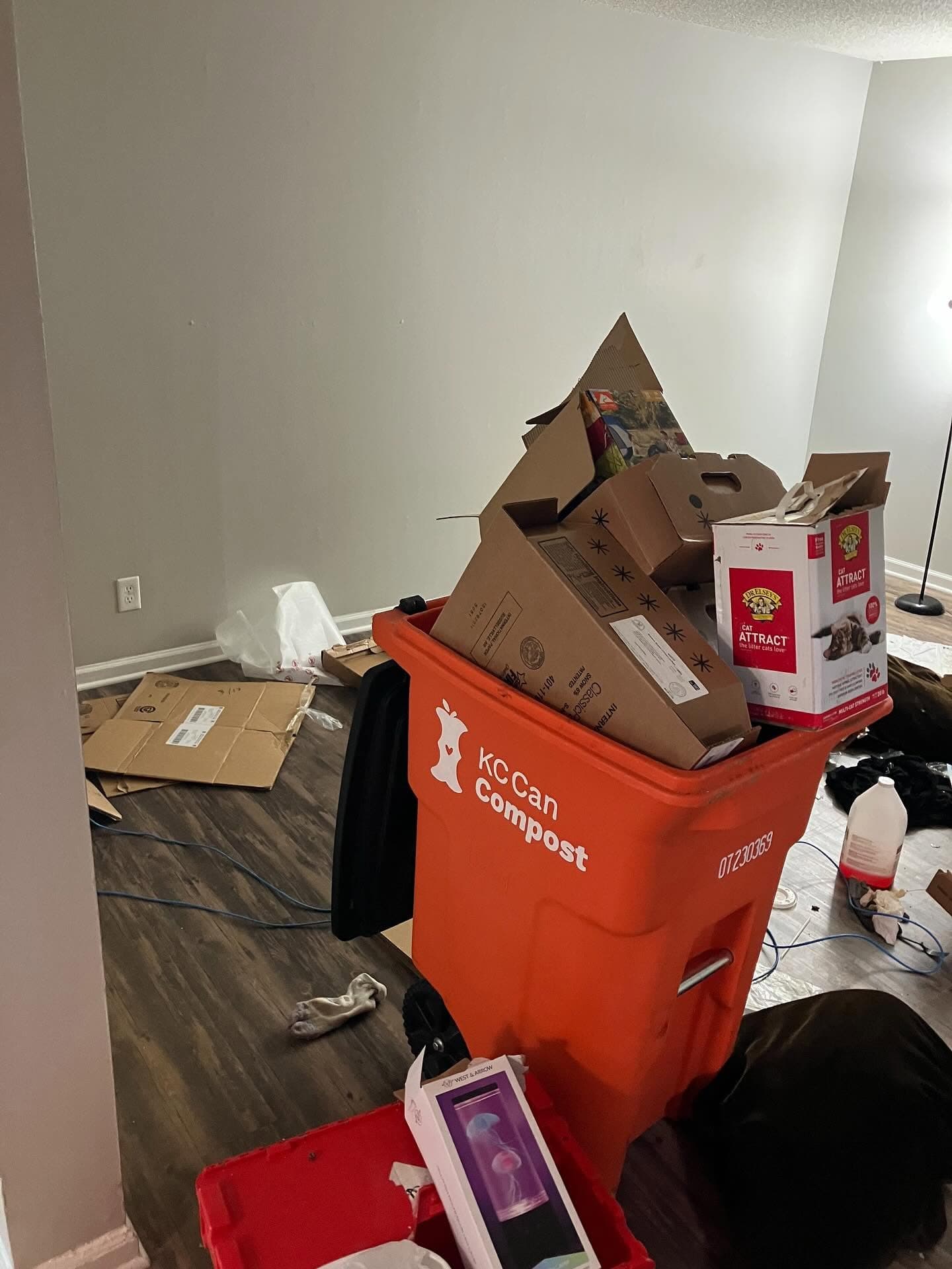 Cleanout sorting bin with boxes and household items.