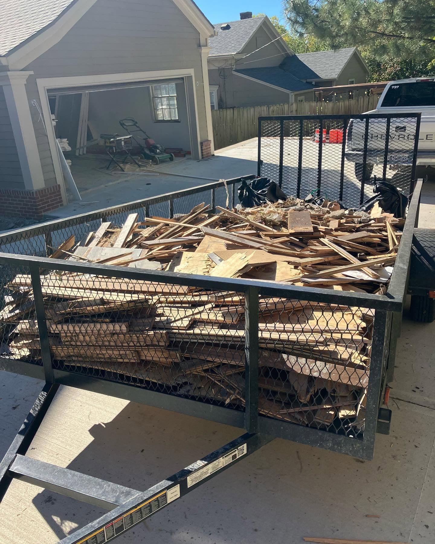 Trailer loaded with renovation debris outside a property.
