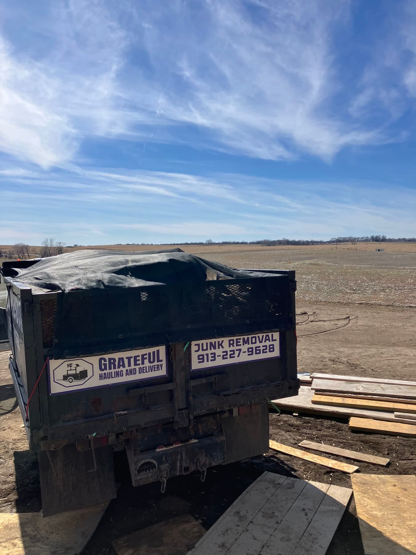 Grateful Hauling truck at a cleanup jobsite with debris loaded for removal