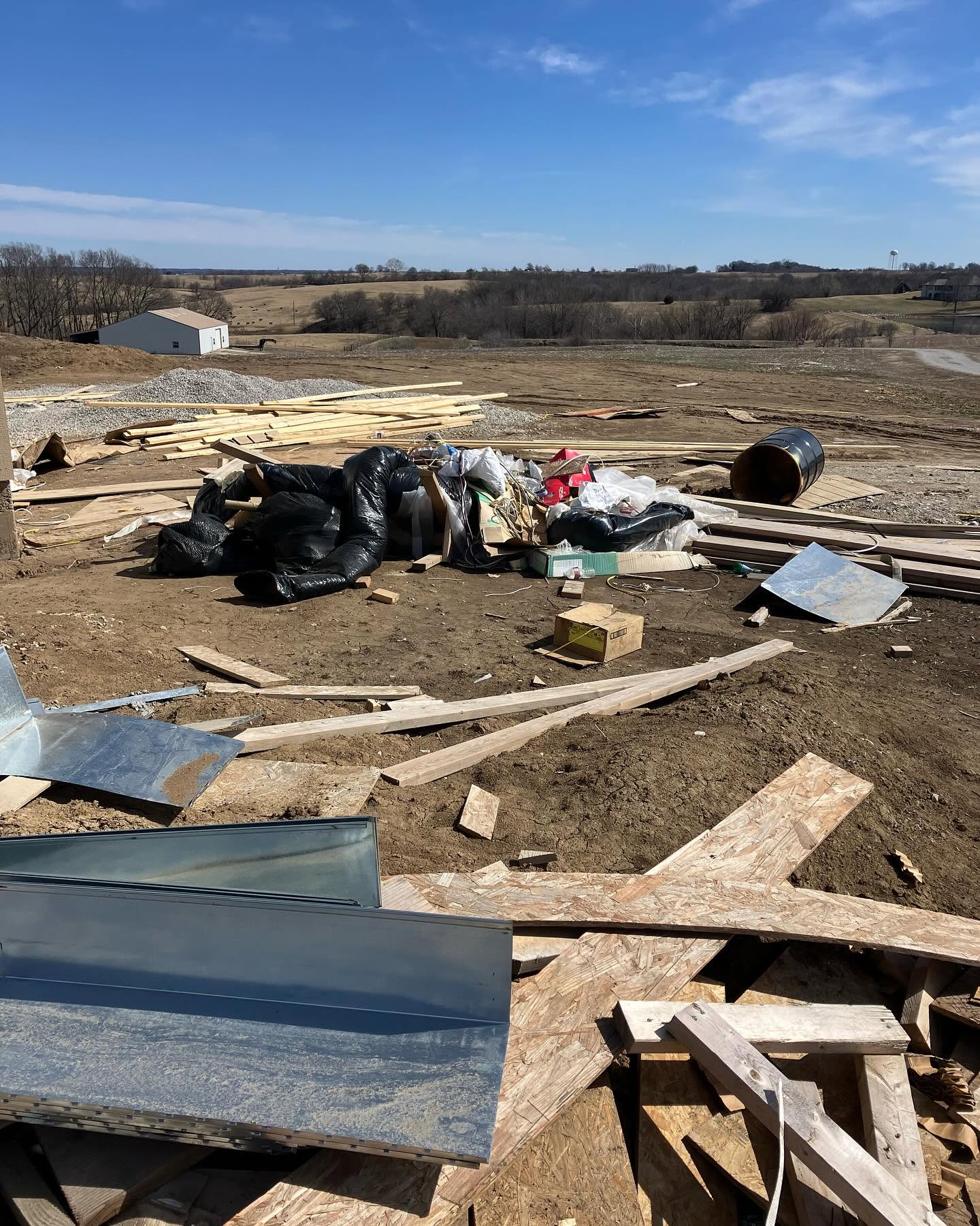 Construction debris and cleanup materials staged at a jobsite