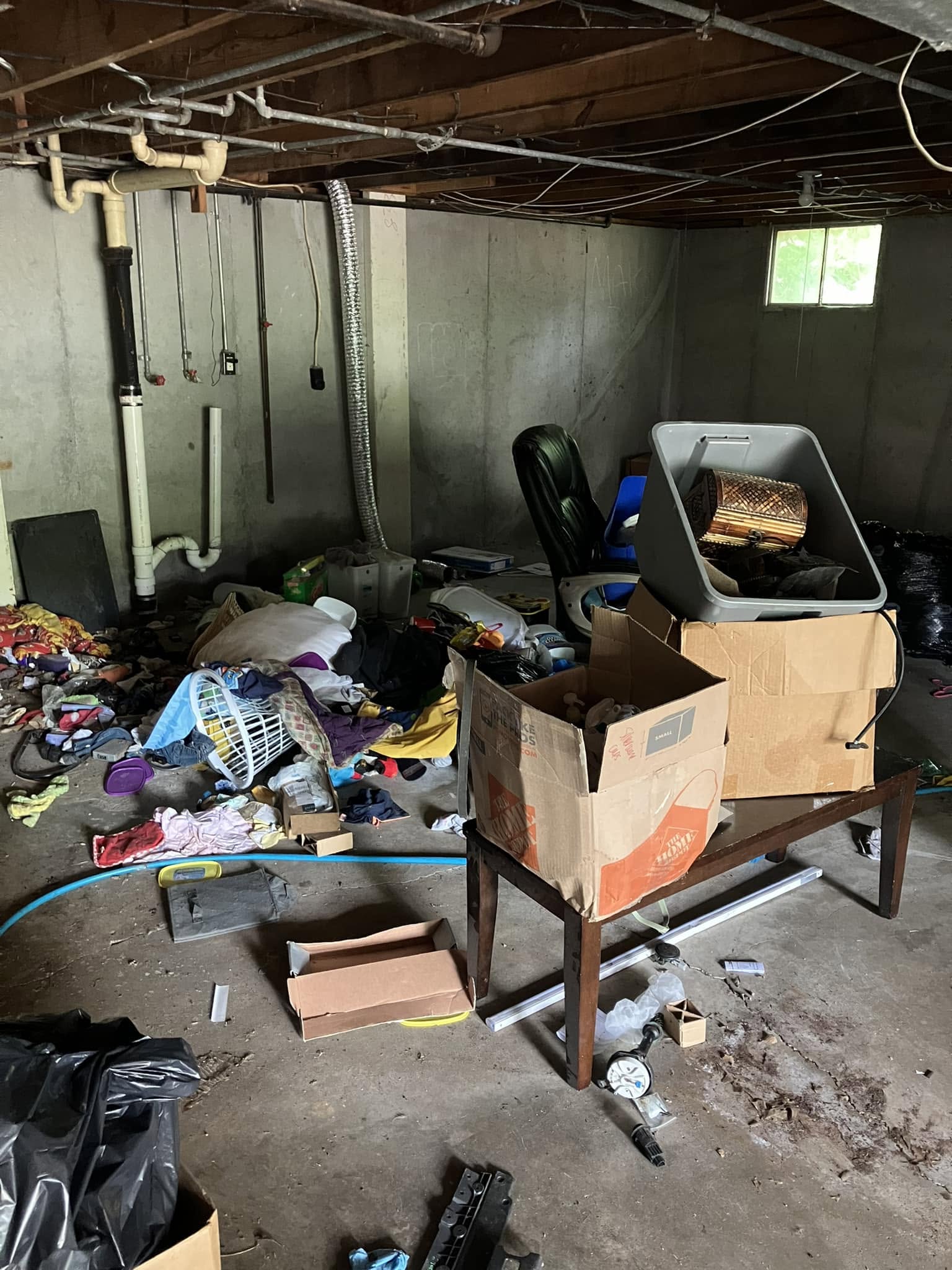 Abandoned items and boxes staged in a basement for an eviction cleanout