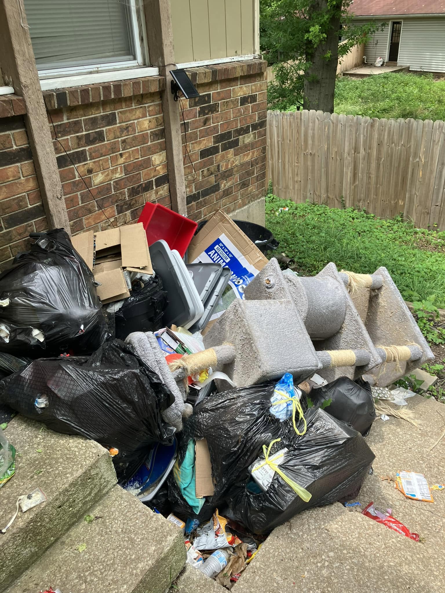 Bags and bulk items staged outside an apartment for set-out hauling